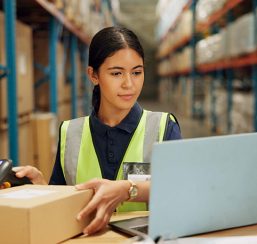 A woman scanning a QR code in a warehouse
