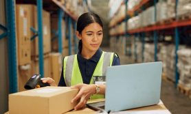 A woman scanning a QR code in a warehouse