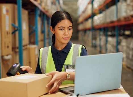 A woman scanning a QR code in a warehouse