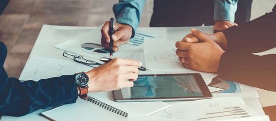 A close up of hands and materials in a meeting