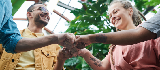 A diverse group of people fist bumping
